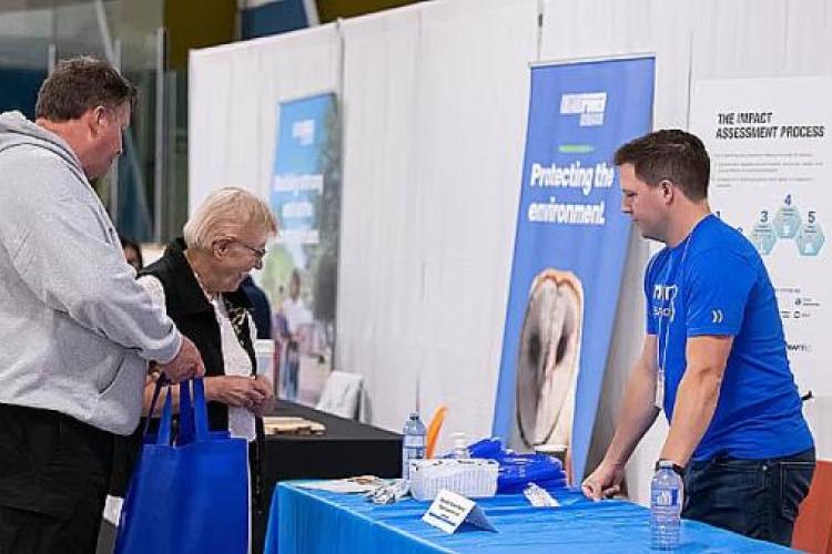 An NWMO employee explains the impact assessment process at an event An NWMO employee explains the impact assessment process at an event